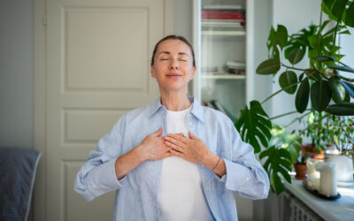 Relaxed smiling woman meditates with hands on chest, practice breathing exercises at home. Self care