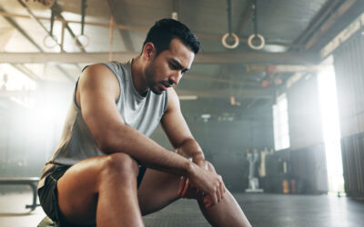 Fitness, breathing and sweating with a tired man in the gym, resting after an intense workout. Exercise, health and fatigue with a young athlete in recovery from training for sports or wellness