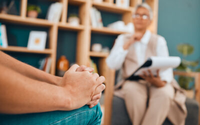Hands, psychology and patient with anxiety in a session for help or mental health counseling. Healthcare, psychiatry and closeup of a woman with depression, trauma or stress speaking to psychologist.