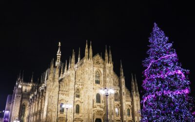 Milan Cathedral and vibrant Christmas tree at night.