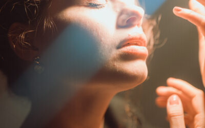 Young woman posing under dreamy light with eyes closed in studio