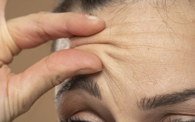 Woman checking her wrinkles on her forehead
