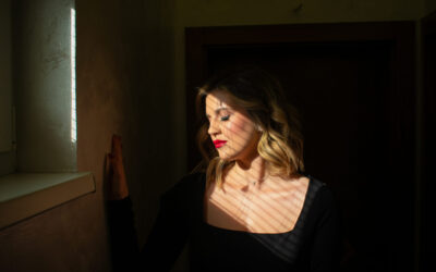 Photo of a woman illuminated by the sun through the window of the room